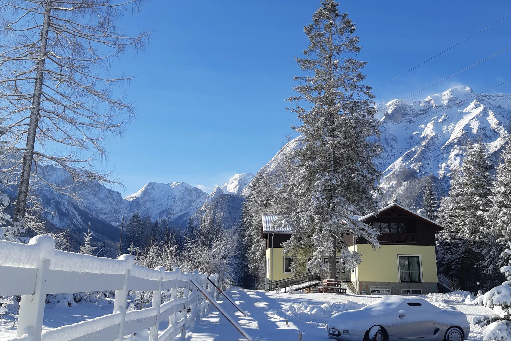 House in Hinterstoder in winter, snow-covered meadow and the mountains of the Pyhrn-Priel region behind