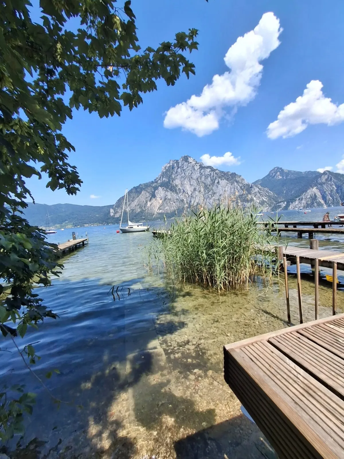 Shallow, clear water at the lake access with reeds and wooden jetties